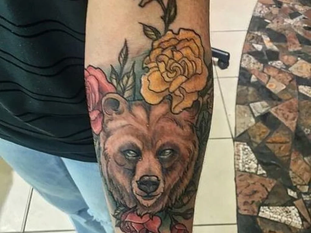 50 Animal Tattoo Ideas: The Complete Guide by Animal, Style and Placement 14 Colour bear face tattoo framed by roses on a forearm