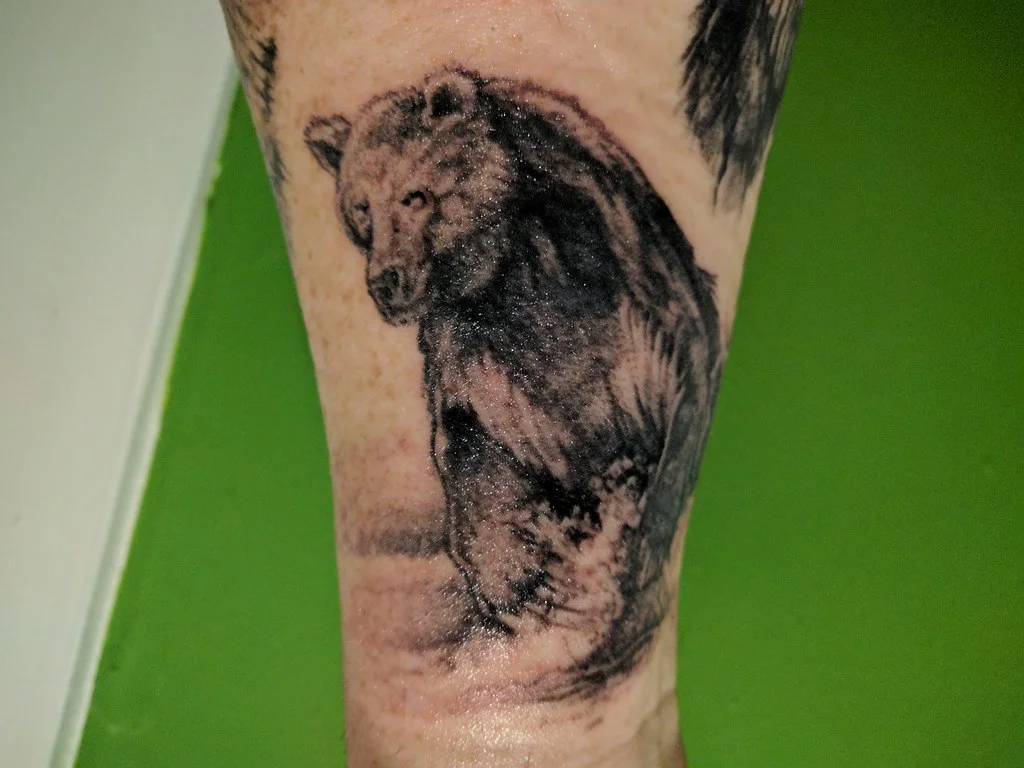 50 Animal Tattoo Ideas: The Complete Guide by Animal, Style and Placement 15 Black and grey standing bear tattoo on a forearm