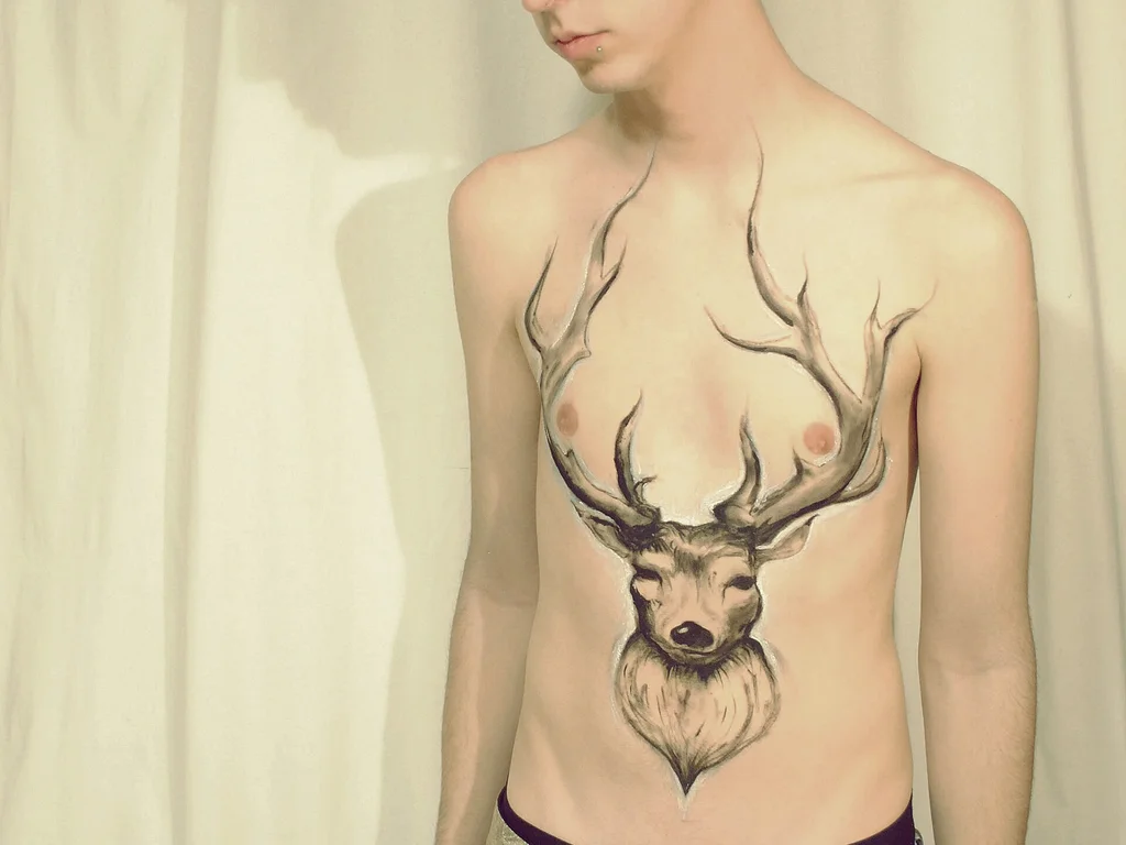 50 Animal Tattoo Ideas: The Complete Guide by Animal, Style and Placement 18 Line work stag head tattoo with large antlers in the centre of a chest