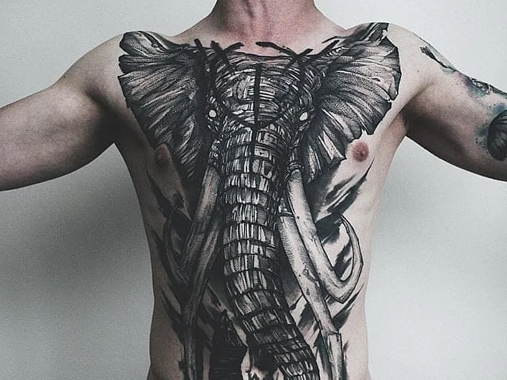 50 Animal Tattoo Ideas: The Complete Guide by Animal, Style and Placement 22 Huge blackwork elephant head tattoo covering a man's chest and stomach