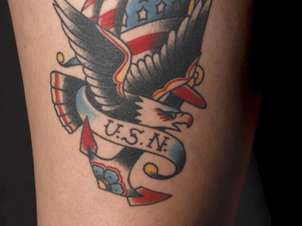 50 Animal Tattoo Ideas: The Complete Guide by Animal, Style and Placement 33 Traditional colour eagle tattoo with an American flag and USN banner on an arm