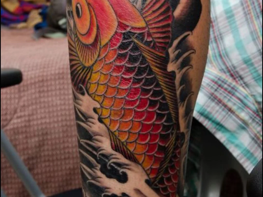 50 Animal Tattoo Ideas: The Complete Guide by Animal, Style and Placement 43 Colour koi carp tattoo in red and orange on a forearm