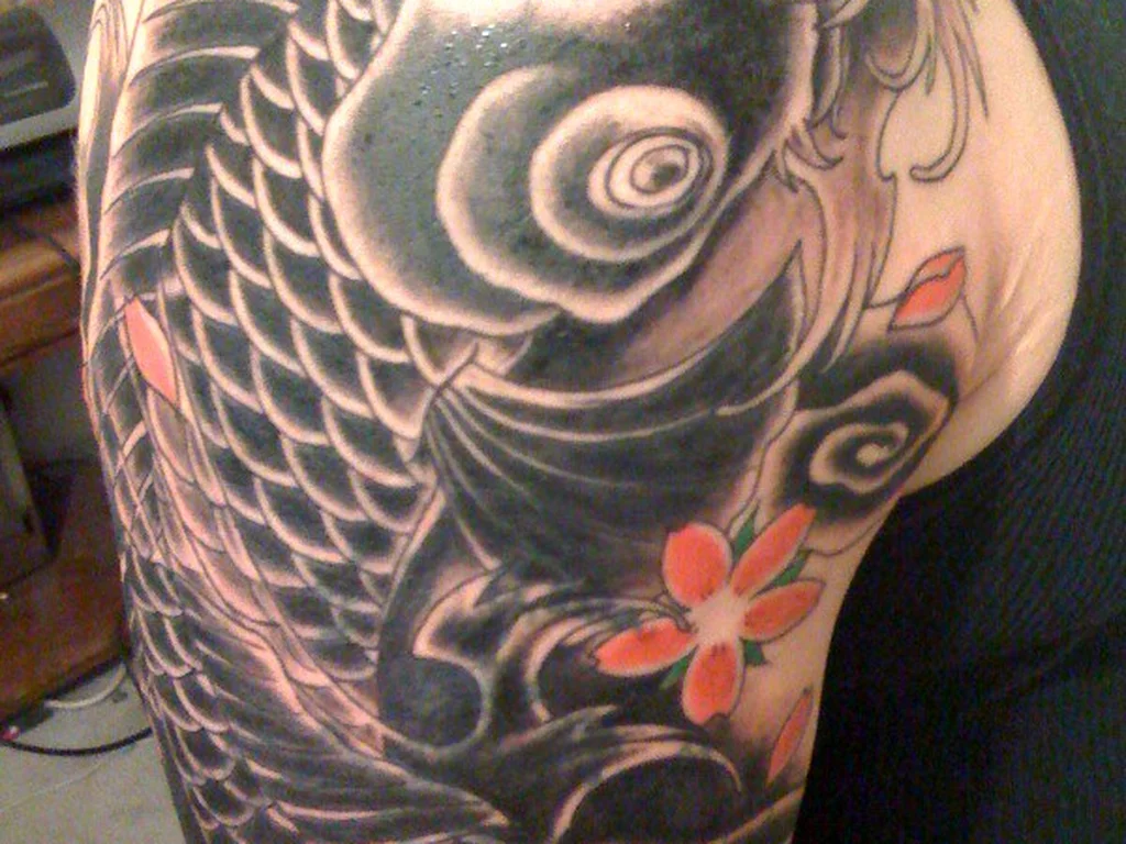 50 Animal Tattoo Ideas: The Complete Guide by Animal, Style and Placement 44 Black koi tattoo with cherry blossom on a shoulder and upper arm