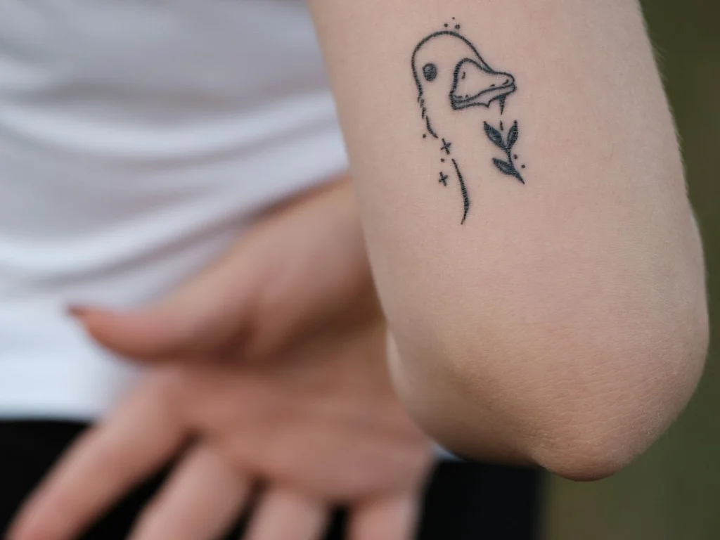 35 Bird Tattoo Ideas: Meanings, Species and Best Placements 8 Tiny fine line duck tattoo on a forearm
