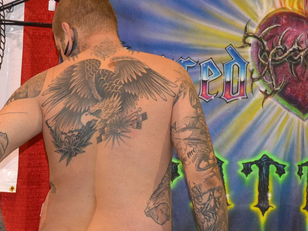 35 Bird Tattoo Ideas: Meanings, Species and Best Placements 11 Large eagle tattoo spread across a man's back