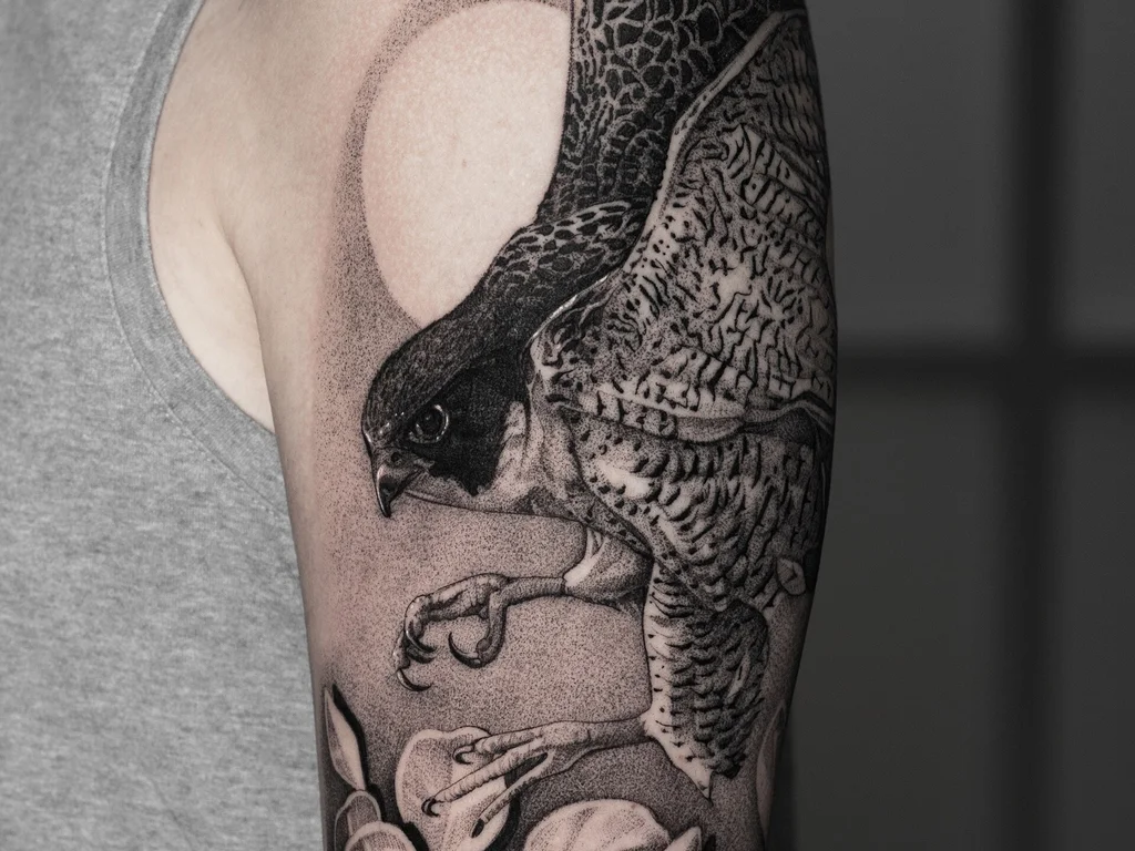 35 Bird Tattoo Ideas: Meanings, Species and Best Placements 16 Blackwork falcon tattoo diving past a moon on an upper arm