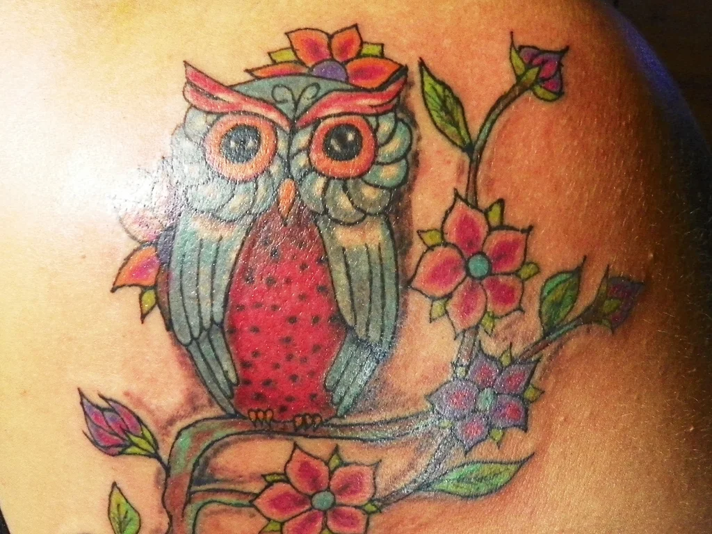 35 Bird Tattoo Ideas: Meanings, Species and Best Placements 19 Colourful owl tattoo with flowers on a shoulder
