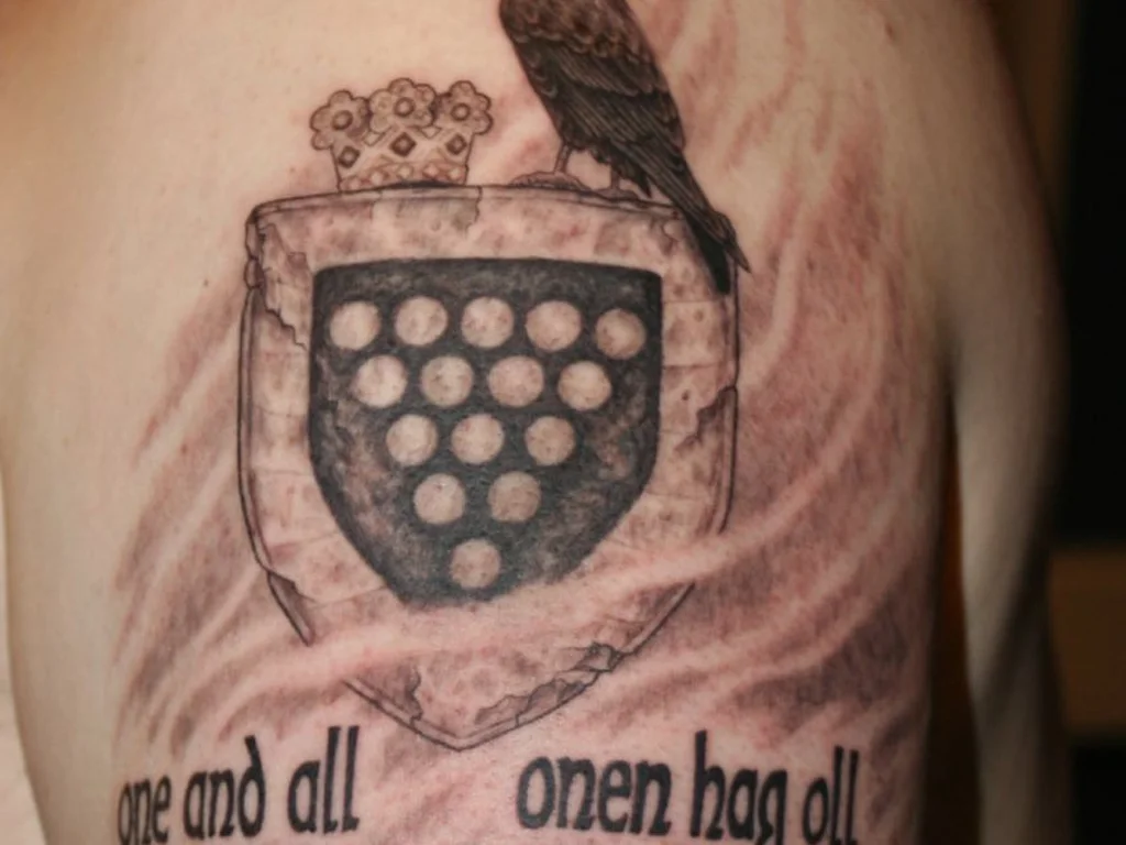 35 Bird Tattoo Ideas: Meanings, Species and Best Placements 30 Crow tattoo perched on a heraldic shield on an upper arm