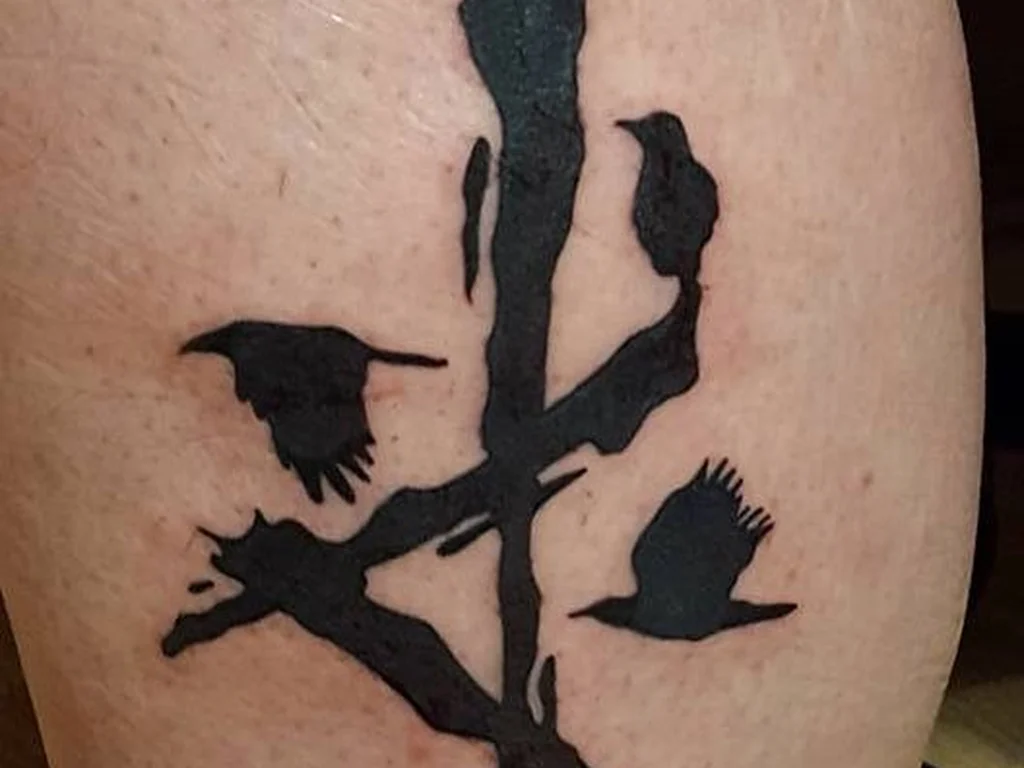 35 Bird Tattoo Ideas: Meanings, Species and Best Placements 31 Two crows on a branch tattoo in a bold brush style
