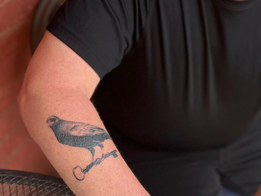 35 Bird Tattoo Ideas: Meanings, Species and Best Placements 32 Crow tattoo perched on a key on a forearm