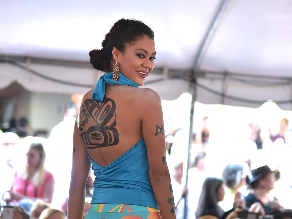 35 Bird Tattoo Ideas: Meanings, Species and Best Placements 33 Formline style bird tattoo across a woman's back