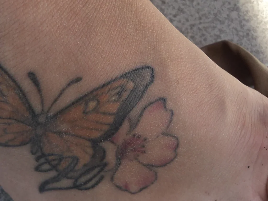 22 Butterfly Tattoo Ideas: Meanings, Styles and Best Placements 9 Butterfly and flower tattoo across the top of a foot