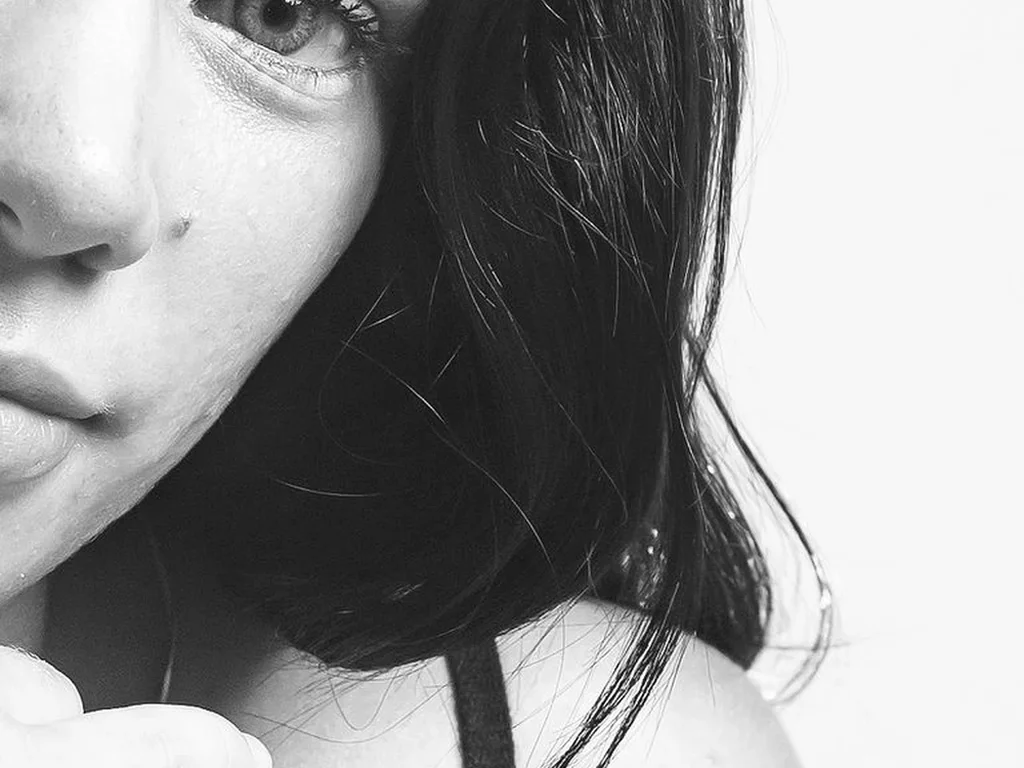 22 Butterfly Tattoo Ideas: Meanings, Styles and Best Placements 14 Dark butterfly tattoo below a collarbone, black and white photo
