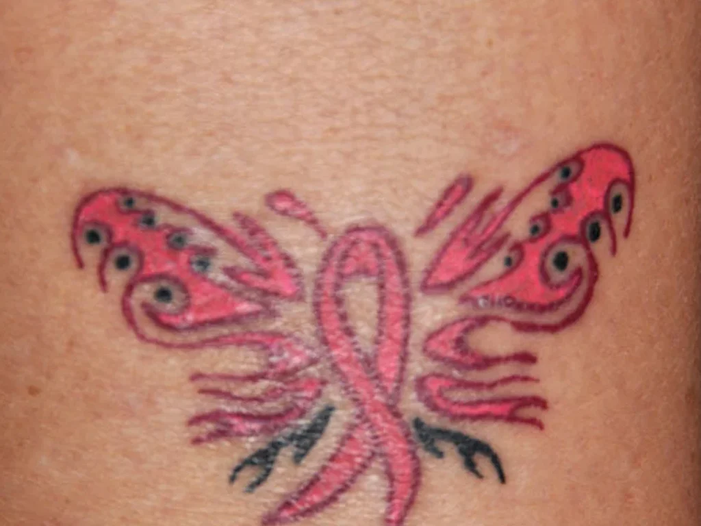 22 Butterfly Tattoo Ideas: Meanings, Styles and Best Placements 18 Pink butterfly tattoo with an awareness ribbon body on an arm