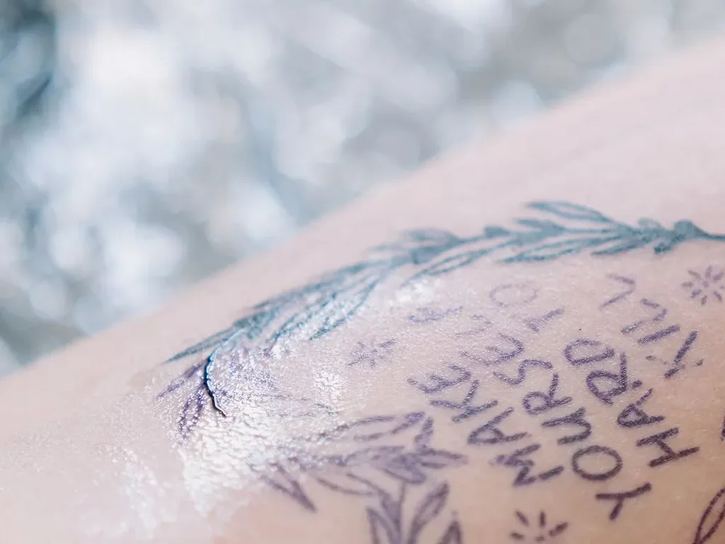 25 Fine Line Tattoo Ideas: Delicate Designs, Honestly Rated 3 Fine line laurel wreath tattoo with the words make yourself hard to kill lettered inside, on an upper arm