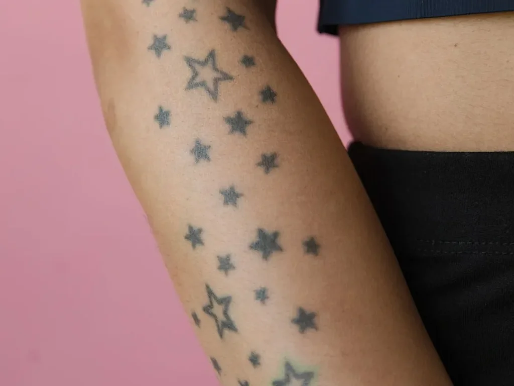 25 Fine Line Tattoo Ideas: Delicate Designs, Honestly Rated 19 Trail of small star tattoos scattered down a forearm