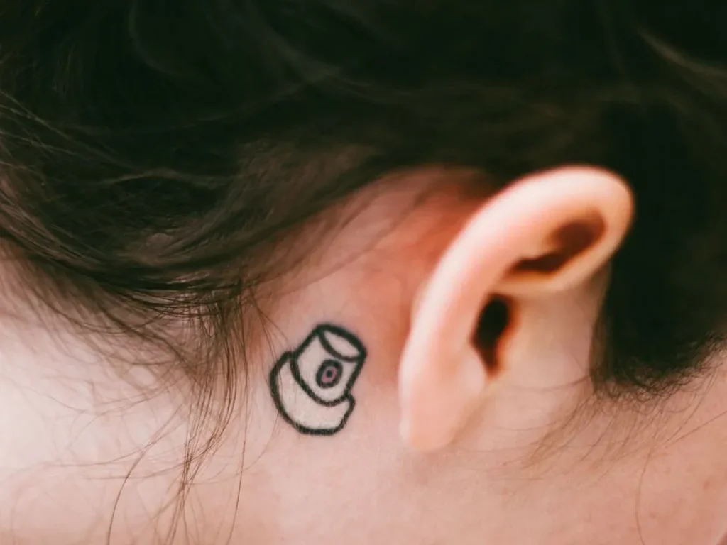25 Fine Line Tattoo Ideas: Delicate Designs, Honestly Rated 21 Small rose outline tattoo tucked behind an ear