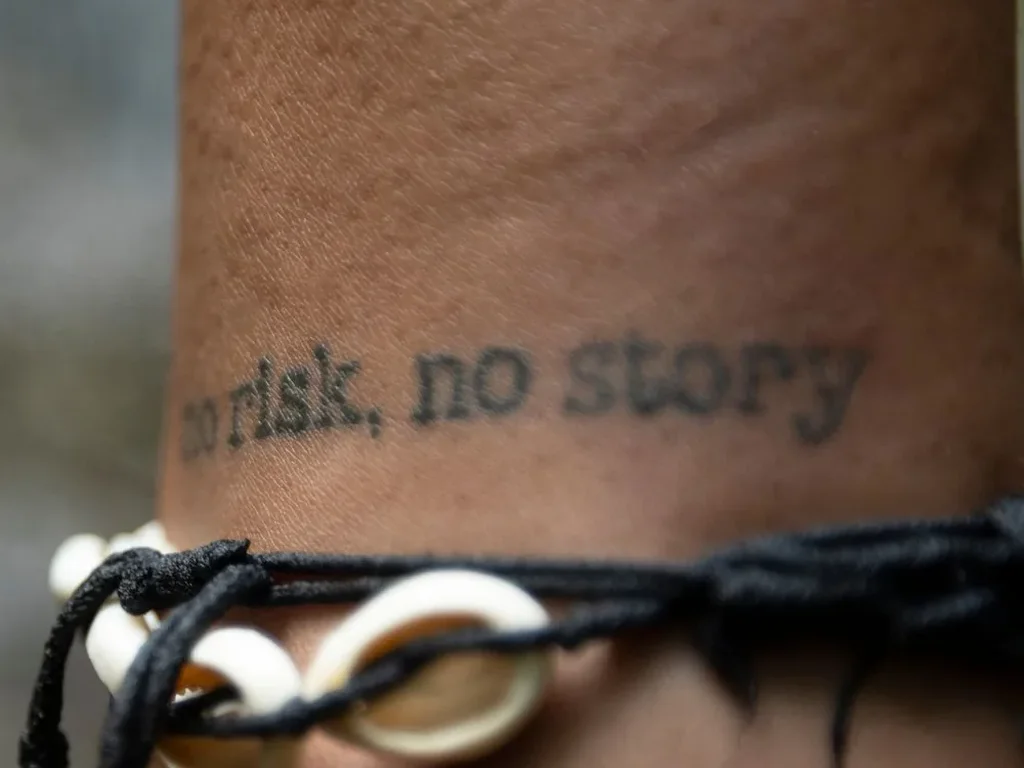 25 Fine Line Tattoo Ideas: Delicate Designs, Honestly Rated 22 Fine script tattoo reading no risk, no story around an ankle, with a shell bracelet above it