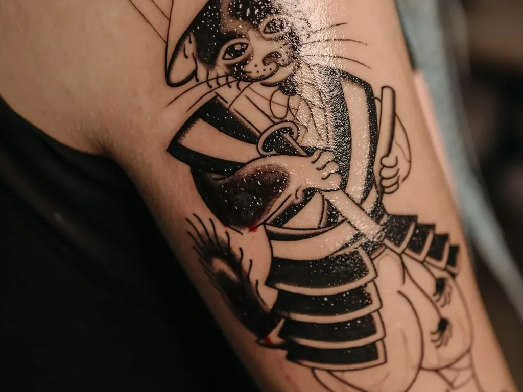 22 Pet Tattoo Ideas: Portraits, Paw Prints and Memorials Done Right 12 Blackwork samurai cat tattoo holding a sword on a forearm
