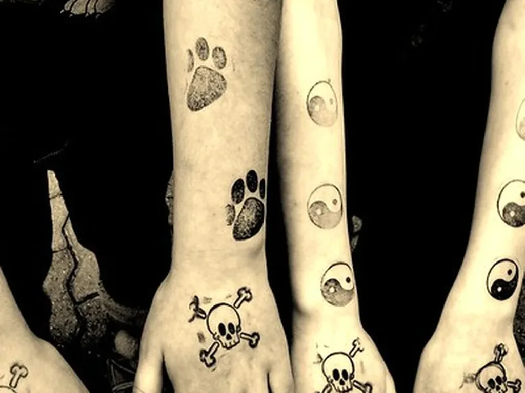 22 Pet Tattoo Ideas: Portraits, Paw Prints and Memorials Done Right 17 Matching small paw print tattoos on the hands and wrists of three friends in black and white