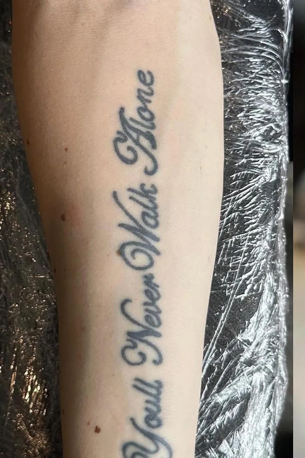 23 Small Tattoos for Women: Tiny Designs That Say a Lot, Quietly 6 Cursive script quote tattoo running down the inner forearm