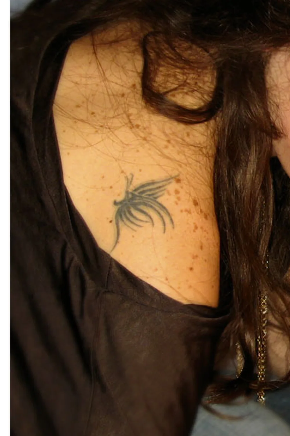 23 Small Tattoos for Women: Tiny Designs That Say a Lot, Quietly 12 Small black spider lily tattoo below the collarbone