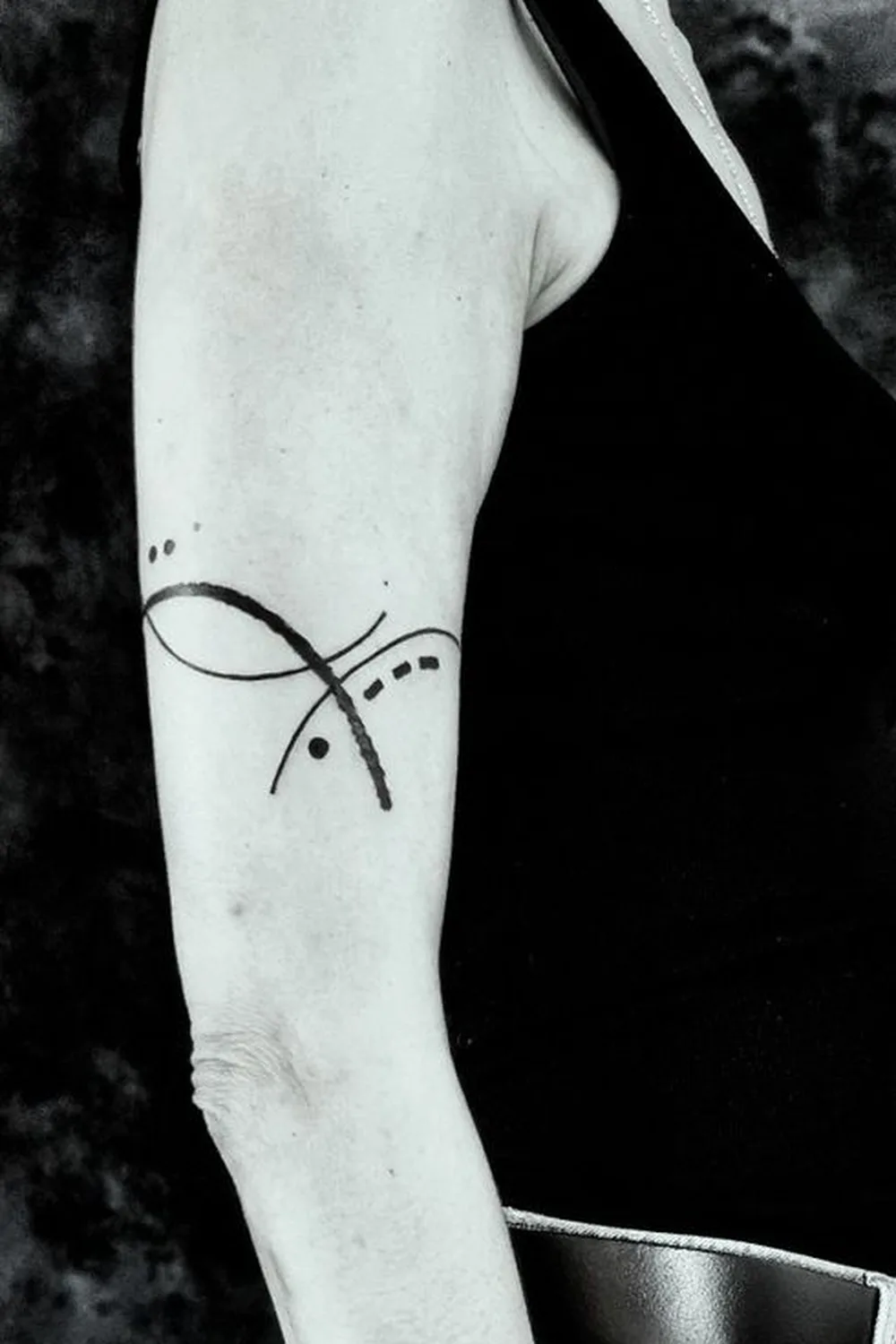 23 Small Tattoos for Women: Tiny Designs That Say a Lot, Quietly 18 Abstract crossed fine lines with dots tattoo on the upper arm