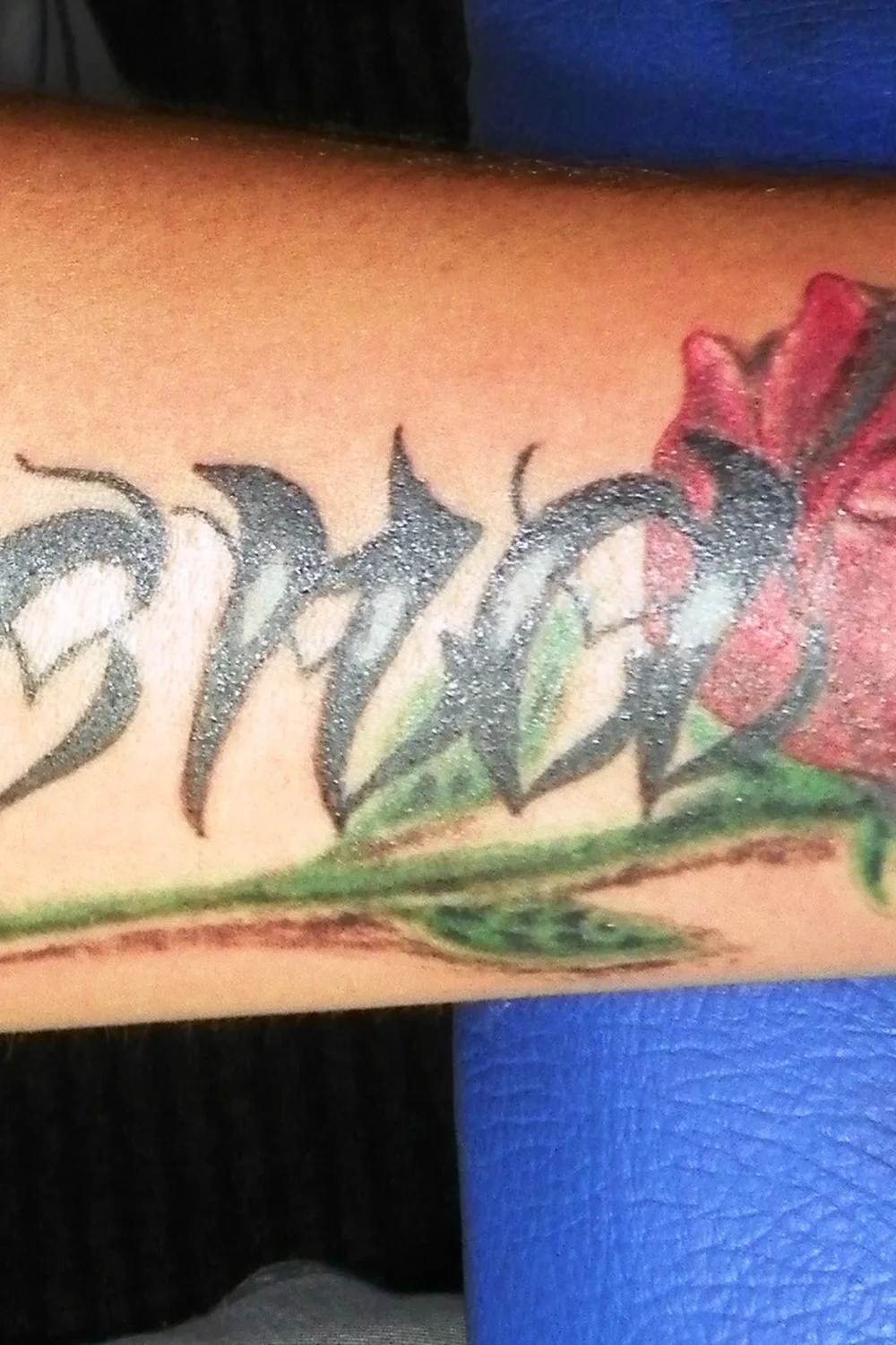 23 Small Tattoos for Women: Tiny Designs That Say a Lot, Quietly 20 Name tattooed in gothic script with a red rose on the forearm