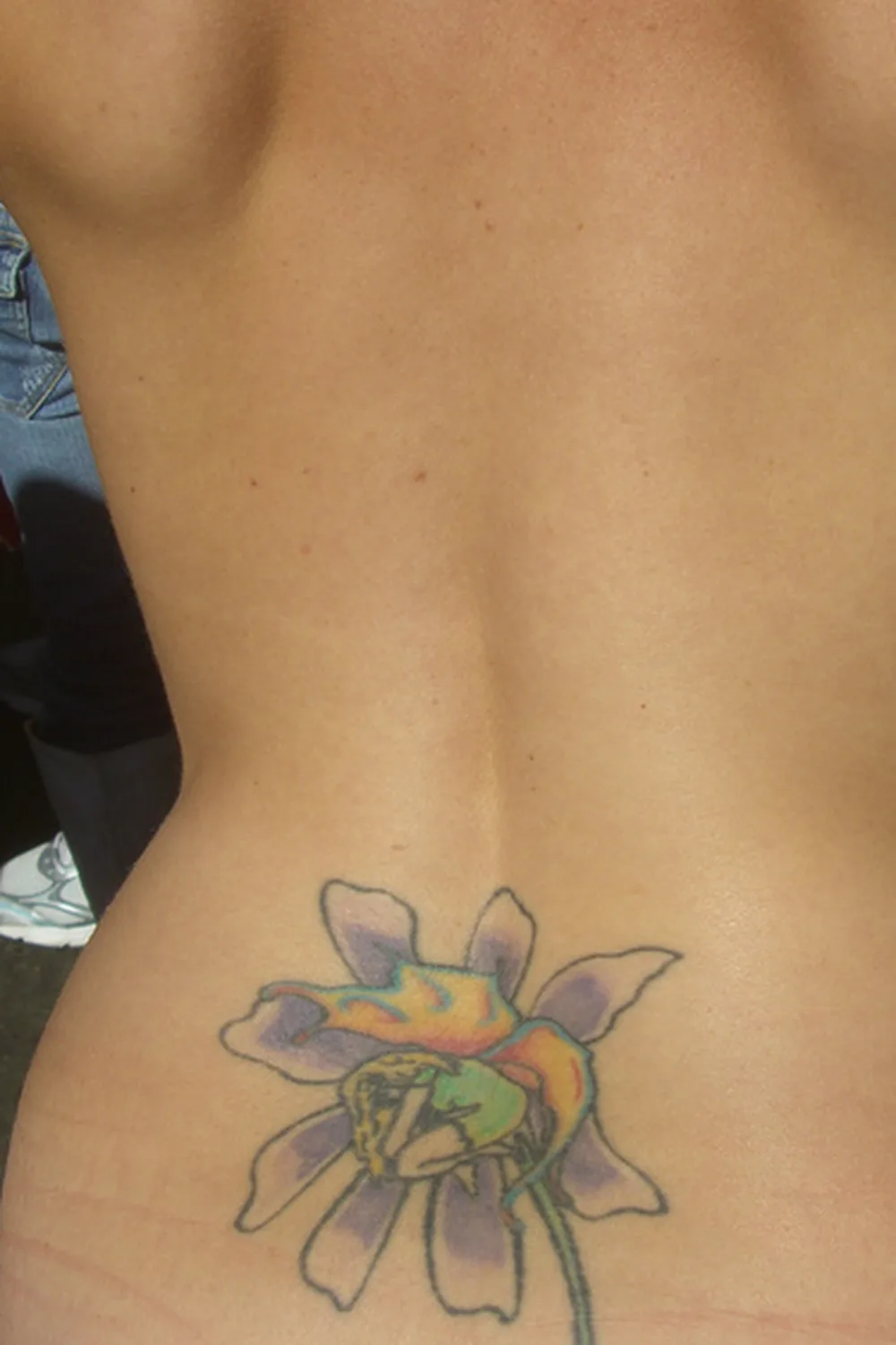 23 Small Tattoos for Women: Tiny Designs That Say a Lot, Quietly 22 Flower tattoo sitting low on the back