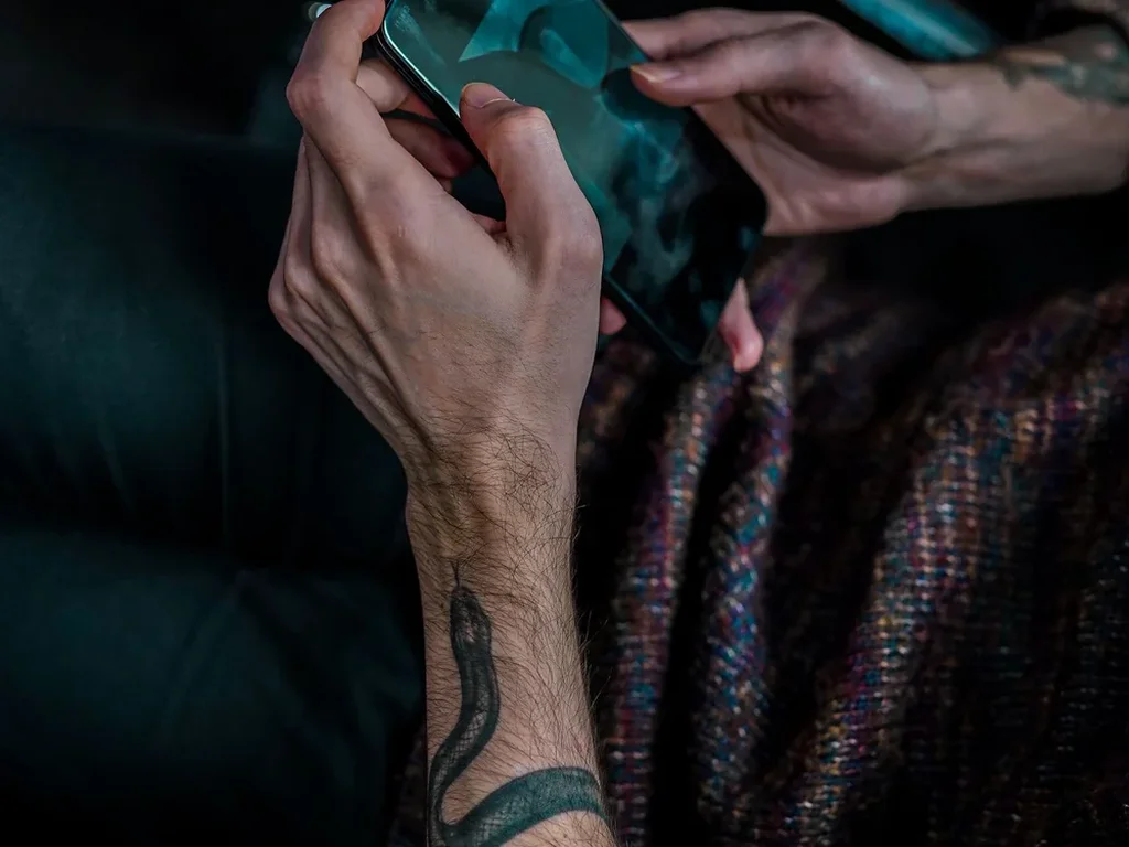 20 Snake Tattoo Ideas: Meanings, Styles and Placements That Work 8 Dark green and black snake tattoo winding up a forearm