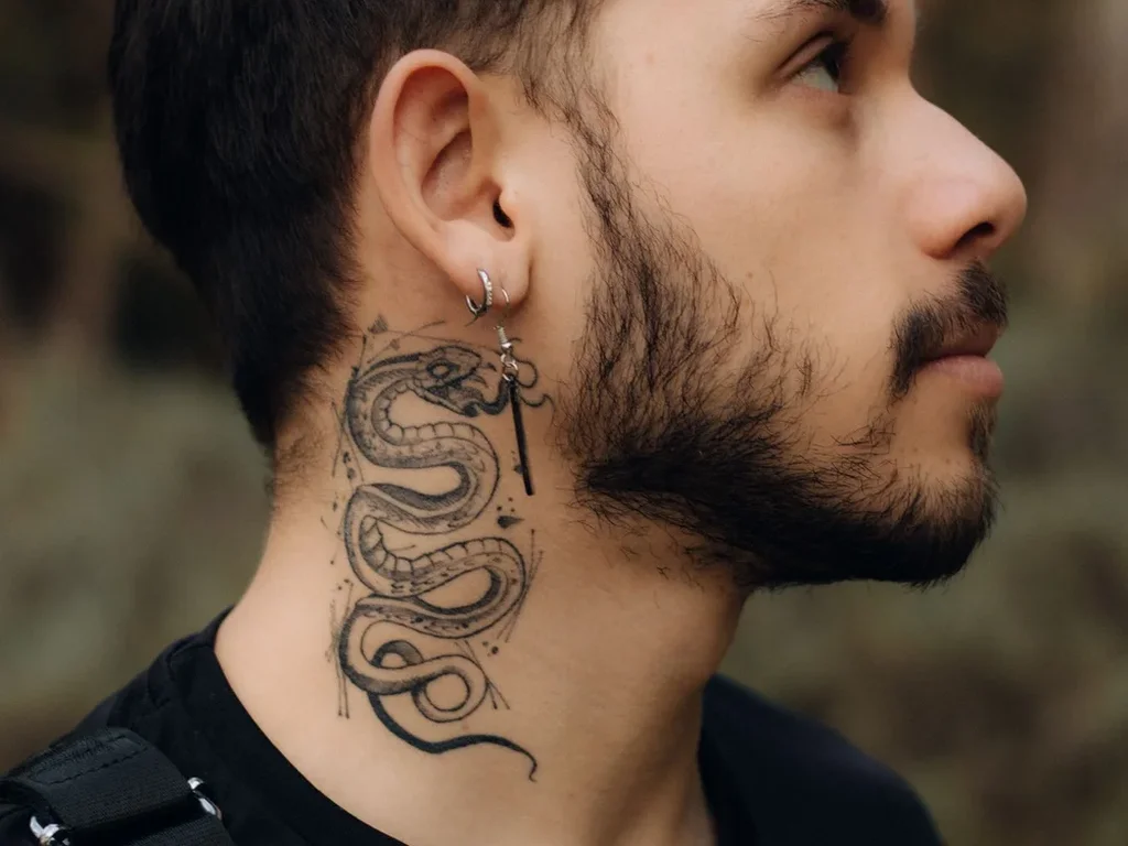 20 Snake Tattoo Ideas: Meanings, Styles and Placements That Work 11 Finely shaded coiled snake tattoo on the side of a man's neck